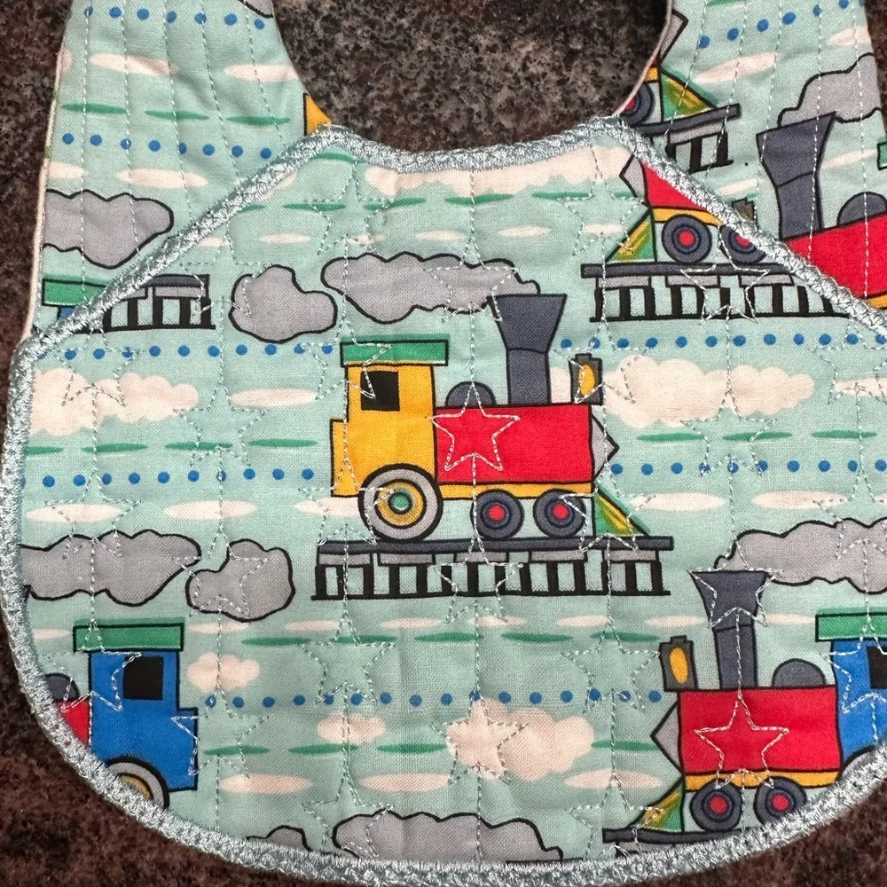Handmade reversible quilted baby bib in train print